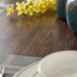 Detailed close-up of a smooth, polished honey-finish solid wood tabletop surface, showcasing organic grain textures.