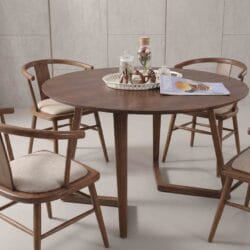 Elegant solid wood round dining table with unique intersecting geometric leg base and matching modern wooden dining chairs.