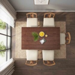 Overhead top-down view of a rectangular solid wood dining table layout featuring six comfortable cream upholstered chairs.