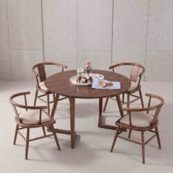 Modern minimalist dining room setting featuring a 4-seater round solid wood dining table and comfortable upholstered wooden chairs.