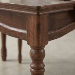Low-angle profile shot of a durable handcrafted solid wood dining table and chair set, emphasizing the sturdy structure and rich polish.