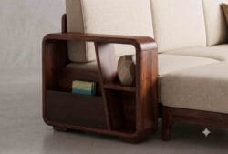 Close-up of an integrated wooden bookshelf armrest and side table on a premium Sheesham wood sectional sofa.