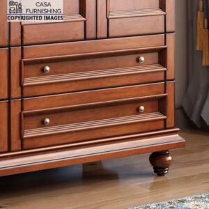 Detailed close-up of the spacious bottom drawers on a traditional wooden almirah highlighting elegant panel molding and classic round bun feet.