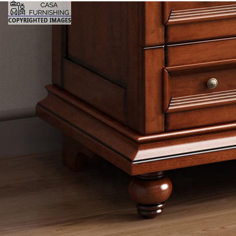 4-door-wardrobe-with-drawers-4-1.jpg Close-up view of the sturdy turned wooden bun feet and decorative traditional plinth molding base of a Casa Furnishing solid wood wardrobe.