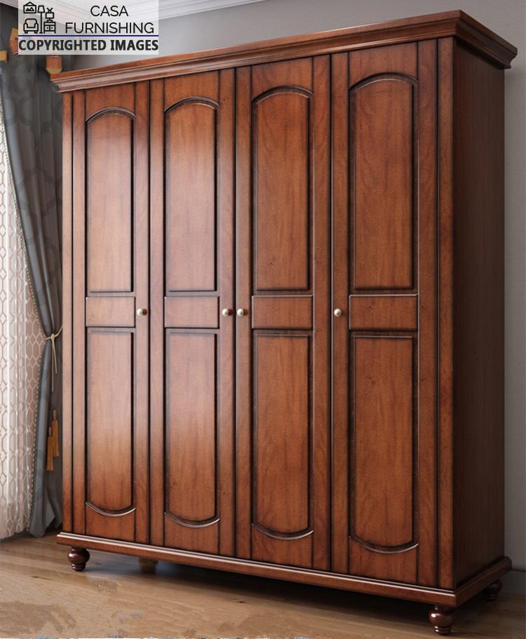 Four-Door-Wardrobe-1-1.jpg Three-quarter side angle view of the luxury classic bedroom clothes closet, showcasing its premium wood grain finish and spacious design in a bright room setting next to window curtains.