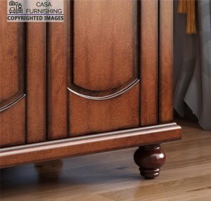 Close-up detail of the traditional wardrobe design craftsmanship, highlighting the elegant arched door panel groove accents and a beautifully turned bun foot.
