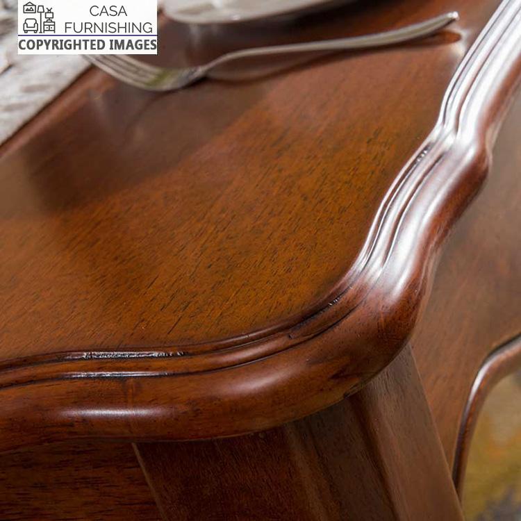dining-room-sets-3-1-1-1-1.jpg Detailed close-up of a premium solid wood dining table corner with a hand-carved scalloped edge and a rich, polished finish by Casa Furnishing.