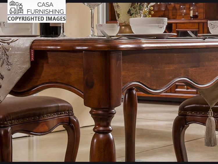 dining-room-sets-7-1-1-1.jpg Detailed close-up of a solid wood dining table from Casa Furnishing, featuring a hand-carved scalloped apron and ornate turned legs in a rich mahogany finish.